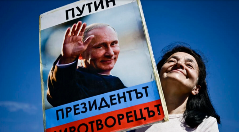 Хора, носещи тениски с руски мечки и размахващи знамена със